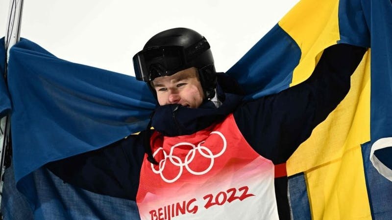 Walter Wallberg holding up a swedish flag after winning the Olympic gold medal